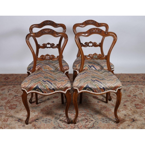 78 - A SET OF FOUR 19TH CENTURY CARVED MAHOGANY DINING ROOM CHAIRS each with a shaped top rail and pierce... 