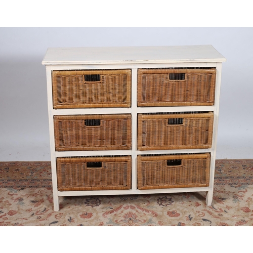 819 - A CREAM PAINTED CHEST of rectangular outline the shaped top above six wicker baskets on moulded legs... 