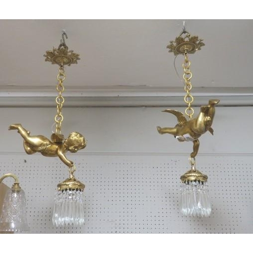 855 - A PAIR OF CONTINENTAL GILT BRASS AND CUT GLASS FIGURAL CENTRE LIGHTS each in the form of a winged ch... 