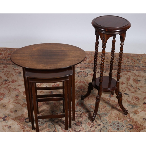 90 - A VINTAGE NEST OF THREE MAHOGANY TABLES on reeded moulded legs joined by cross stretchers 
The large... 