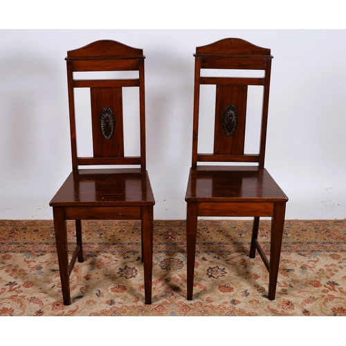 72 - A PAIR OF VINTAGE MAHOGANY HALL CHAIRS each with a shaped top rail above a panelled back with oval p... 