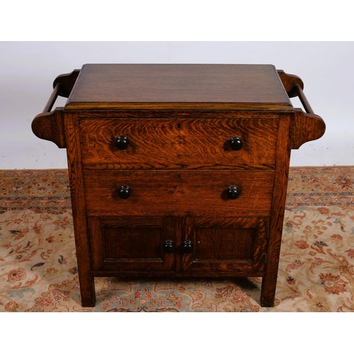 73 - A VINTAGE OAK CHEST of rectangular outline the shaped top with two long drawers and cupboards flanke... 