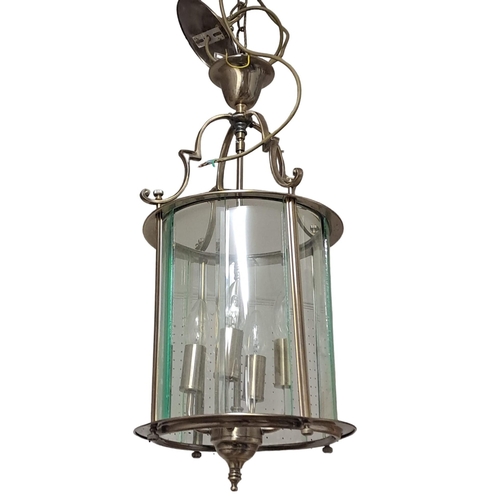 818 - A WHITE METAL FOUR LIGHT LANTERN of cylindrical form with bevelled glass panels and scroll arms 
58c... 