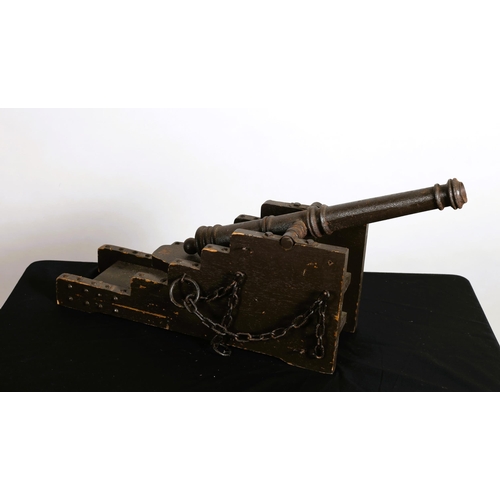 140 - A VINTAGE CAST IRON MINIATURE CANNON on a stained pine wood carriage with link chains
31cm (h) x 76c... 