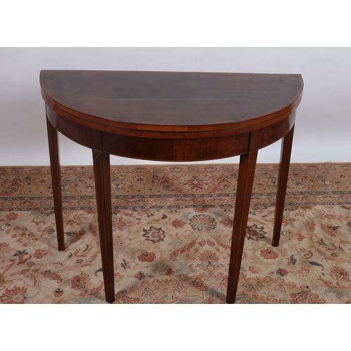 205 - A GEORGIAN MAHOGANY AND SATINWOOD CROSSBANDED FOLDOVER CARD TABLE of demi lune outline the shaped hi... 