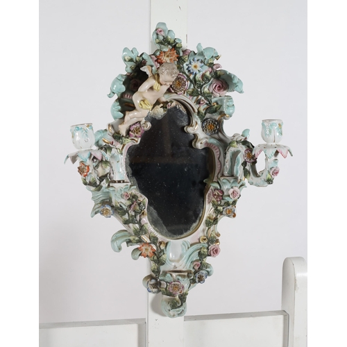 225 - A PAIR OF CONTINENTAL PORCELAIN FLOWER ENCRUSTED GIRANDOLE MIRRORS surmounted by winged cherubs abov... 