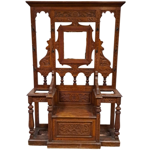 370 - AN EDWARDIAN CARVED OAK HALL STAND centred by a rectangular mirror with nine brass hooks above a hin... 