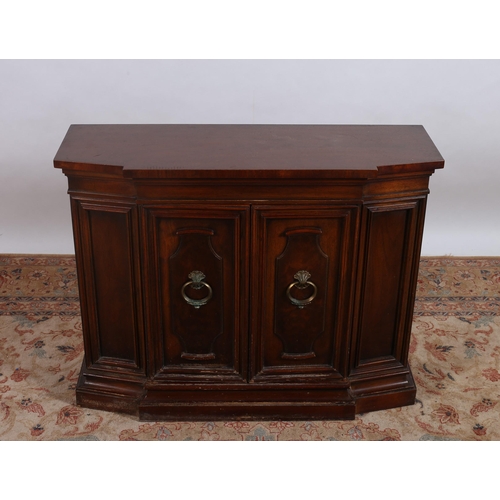 452 - A CONTINENTAL MAHOGANY SIDE CABINET of breakfront outline the shaped top above a pair of panelled do... 