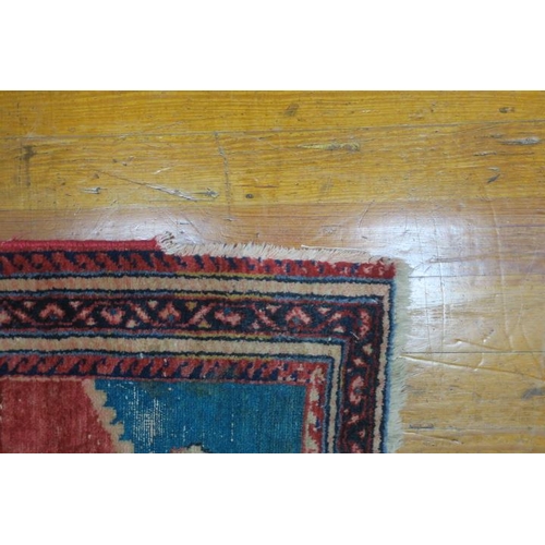 579 - AN ORIENTAL WOOL RUG the wine turquoise ground with central panel filled with stylised flowerheads a... 