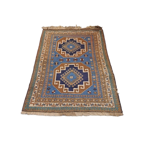 580 - A TURKISH TRIBAL WOOL RUG the light blue, indigo and light brown ground with central panels filled w... 