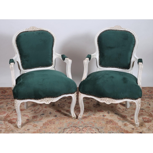 627 - A PAIR OF CONTINENTAL PAINTED AND UPHOLSTERED ARMCHAIRS each with a foliate carved top rail with uph... 