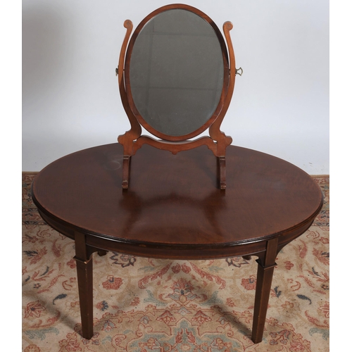 630 - A VINTAGE MAHOGANY CRUTCH FRAME  MIRROR of oval outline with splayed legs and scroll toes together w... 