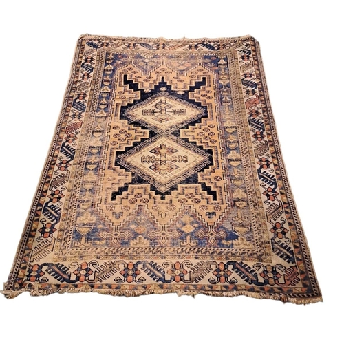 741 - AN IRANIAN WOOL RUG the indigo and wine ground filled with serrated panels, flowerheads and hooks wi... 