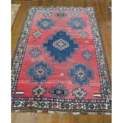 744 - AN ORIENTAL WOOL RUG the light pink ground with central panels filled with stylised flowerheads, hoo... 