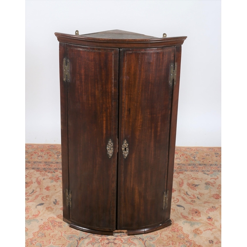 753 - A GEORGIAN MAHOGANY AND SATINWOOD INLAID HANGING CORNER CUPBOARD the moulded cornice above a pair of... 