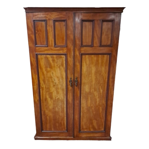 754 - A VINTAGE MAHOGANY TWO DOOR WARDROBE the moulded cornice above a pair of panelled doors containing h... 