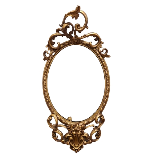 132 - A 19TH CENTURY GILTWOOD AND GESSO MIRROR the oval plate within a gadrooned frame with C-scroll crest... 