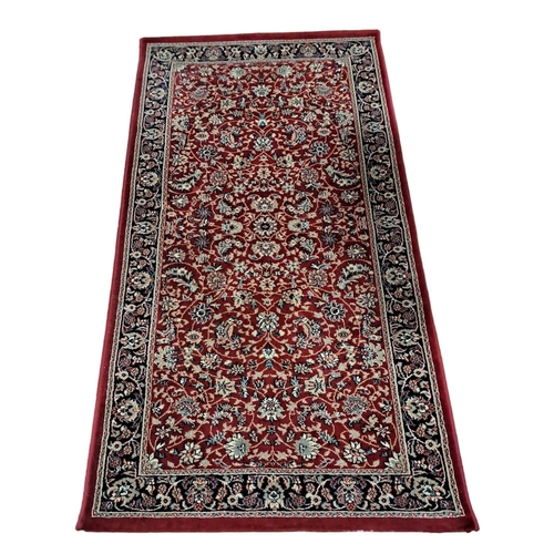 150 - A WOOL RUNNER the wine ground with central stylised floral panel within a conforming border 
350cm (... 