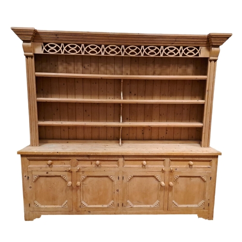 192 - A PINE OPEN FRONT DRESSER the stepped moulded cornice with pierced frieze above four open shelves be... 