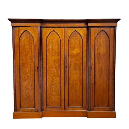 194 - A 19TH CENTURY GOTHIC DESIGN POLLARD OAK WARDROBE of inverted breakfront outline the moulded cornice... 