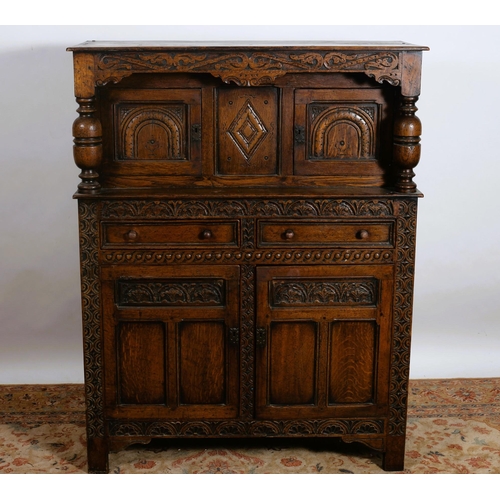 197 - A VINTAGE GOTHIC DESIGN CARVED OAK COURT CUPBOARD of rectangular outline the shaped top above three ... 