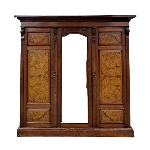 200 - AN EDWARDIAN MAHOGANY AND WALNUT WARDROBE the moulded cornice above a central bevelled glass mirrore... 