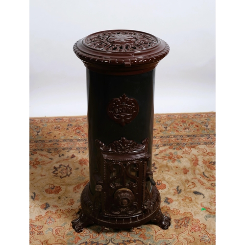 202 - A GODIN CAST IRON FREESTANDING SOLID FUEL STOVE of cylindrical form on splayed legs with scroll toes... 