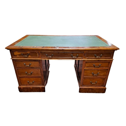 210 - A YEW WOOD PEDESTAL DESK of rectangular outline the shaped top with tooled leather inset above three... 