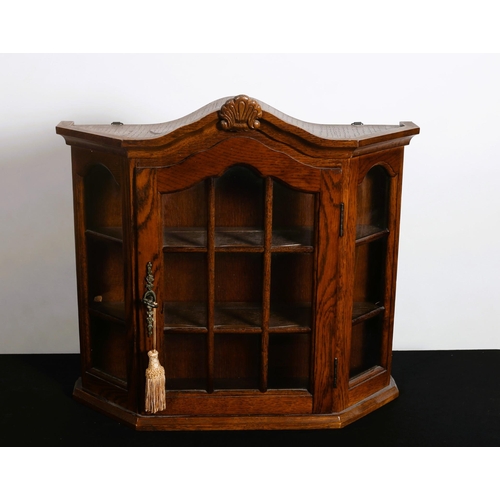 217 - A GOTHIC DESIGN MINIATURE WALL MOUNTED CABINET of rectangular bowed outline the shaped top with shel... 