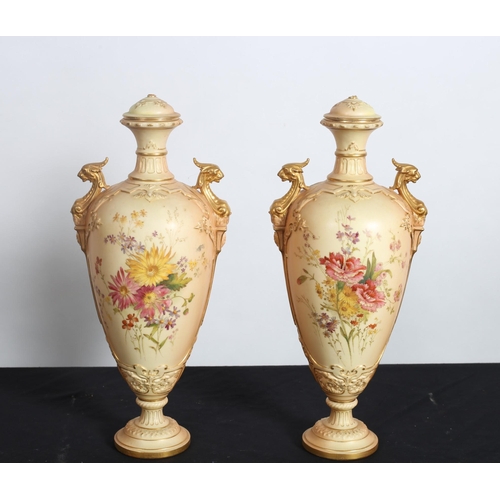 219 - A PAIR OF ROYAL WORCESTER LIDDED VASES each of ovoid tapering form with figural mask handles raised ... 