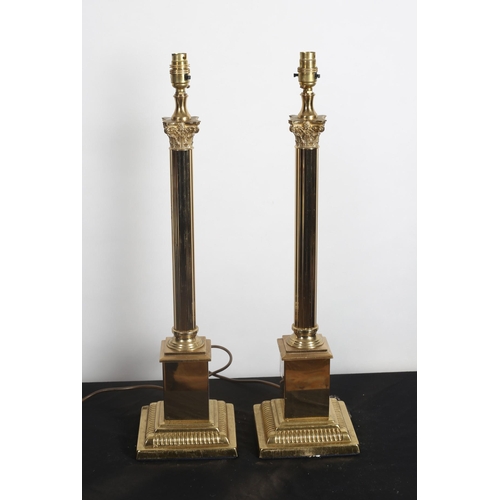 222 - A PAIR OF BRASS CORINTHIAN COLUMN TABLE LAMPS each with a reeded column above a square stepped base ... 