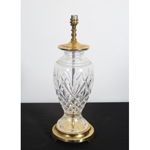 232 - A WATERFORD CUT GLASS AND GILT BRASS TABLE LAMP of baluster form raised on a gilt brass spreading fo... 