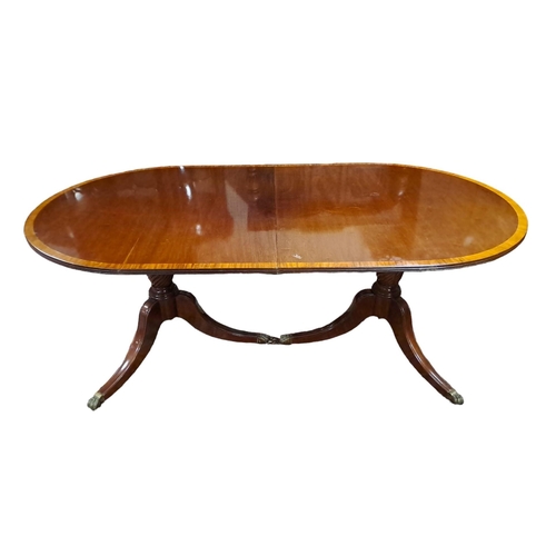 272 - A REGENCY DESIGN MAHOGANY CROSSBANDED TWO POD DINING TABLE of rectangular outline with rounded ends ... 