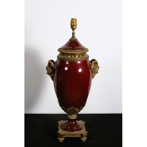 313 - A CONTINENTAL PORCELAIN AND GILT BRASS MOUNTED TABLE LAMP of bulbous form with ram head mask handles... 