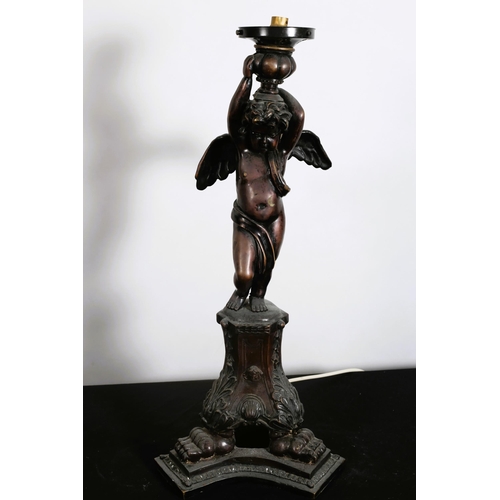 314 - A BRONZE FIGURAL TABLE LAMP modelled as a winged cherub shown standing on a triform base with claw f... 