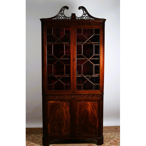 354 - A GEORGIAN MAHOGANY AND SATINWOOD INLAID CORNER CABINET the pierced swan neck pediment above a pair ... 