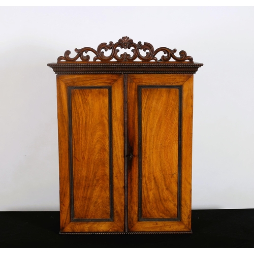 433 - A REGENCY ROSEWOOD WALL MOUNTED CABINET of rectangular outline with pierced C-scroll cresting above ... 