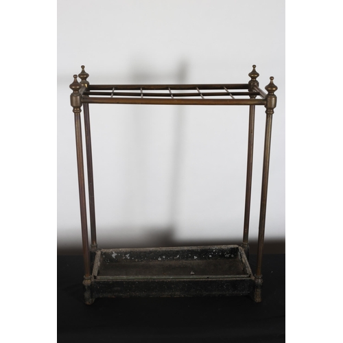 434 - A 19TH CENTURY BRASS AND CAST IRON TWELVE COMPARTMENT STICK STAND of rectangular outline on cylindri... 