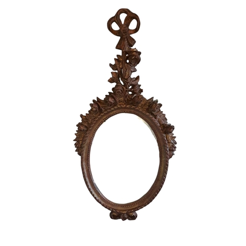 460 - A CONTINENTAL GILT FRAME MIRROR the oval plate within a roped and beadwork moulded frame with ribbon... 