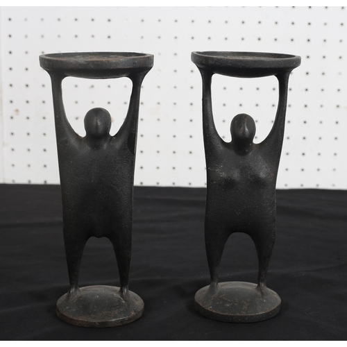 487 - OISIN KELLY CAST IRON CANDLE HOLDERS in the form of a male and female each shown standing holding a ... 