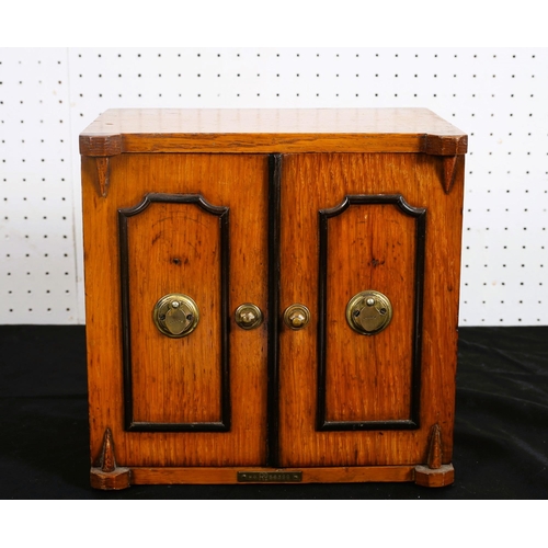 494 - A 19TH CENTURY OAK MINIATURE CHEST in the form of a safe of rectangular outline the shaped top above... 