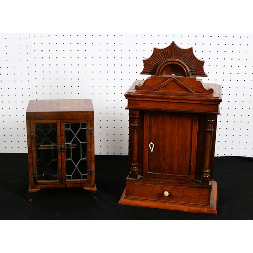 497 - A MINIATURE WALNUT DISPLAY CABINET of rectangular outline the shaped top above a pair of astragal gl... 