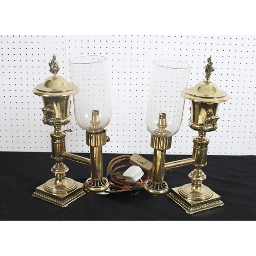 503 - A PAIR OF BRASS AND GLAZED STUDENT LAMPS each of urn form with glazed shades raised on a square step... 