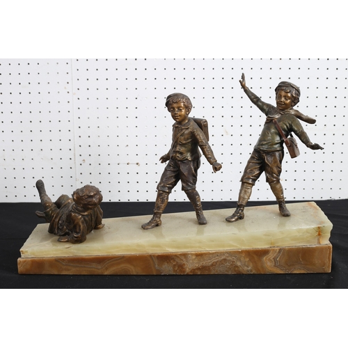 507 - RUFFONY, ITALIAN SCHOOL 
A bronze group modelled as three school boys skating surmounted by an onyx ... 