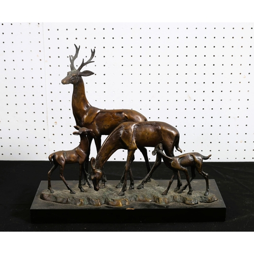 513 - A BRONZE GROUP modelled as a stag, doe and fawn shown standing on a naturalistic base raised on a ha... 