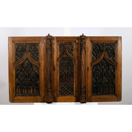 594 - A 19TH CENTURY CARVED OAK GOTHIC TRACERY TRIPLE PANEL with spiral twist pilasters within a moulded f... 