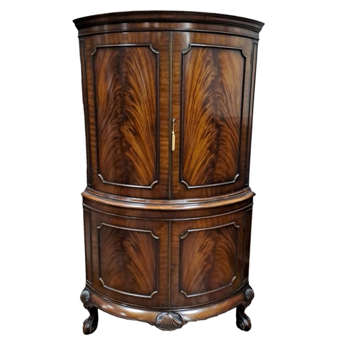 61 - A MAHOGANY CORNER COCKTAIL CABINET the moulded cornice above a pair of panel doors containing a mirr... 