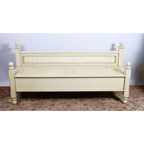 634 - A CREAM PAINTED SEAT of rectangular outline the moulded back above a hinged compartment the base on ... 