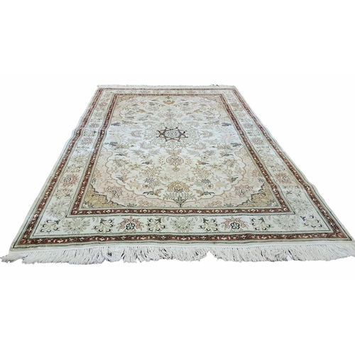 746 - AN ORIENTAL SILK AND WOOL RUG the beige ground with central stylised flowerhead and foliate panel wi... 