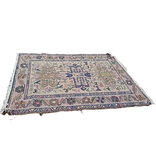 748 - AN ORIENTAL WOOL RUG the central panel filled with geometric panels within a serrated and hook borde... 